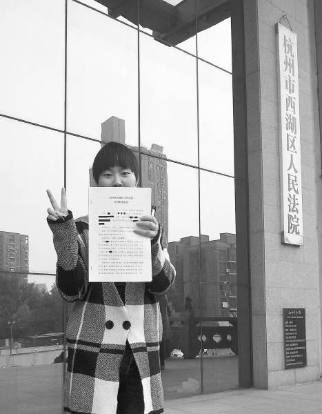 左手举着判决书，右手比着“V”，黄蓉（化名）在浙江省杭州市西湖区人民法院门口，拍下了拿到判决书的这一刻。黄蓉供图
